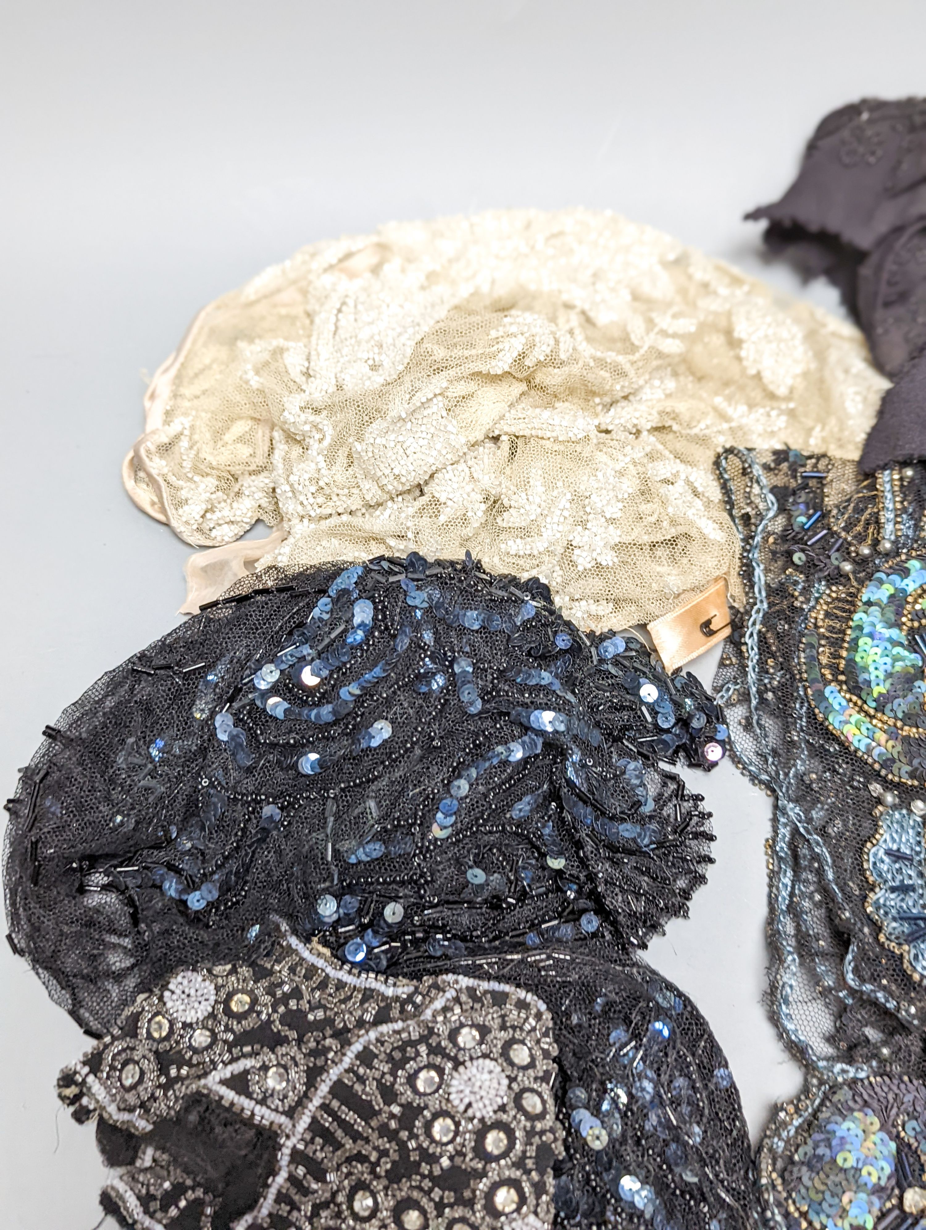 A collection of Edwardian and later sequin and beaded panels on net, a black beaded stole, various buttons etc.